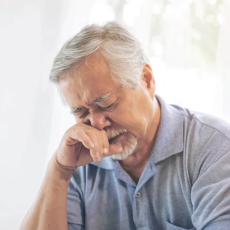 Older man experiencing allergy symptoms